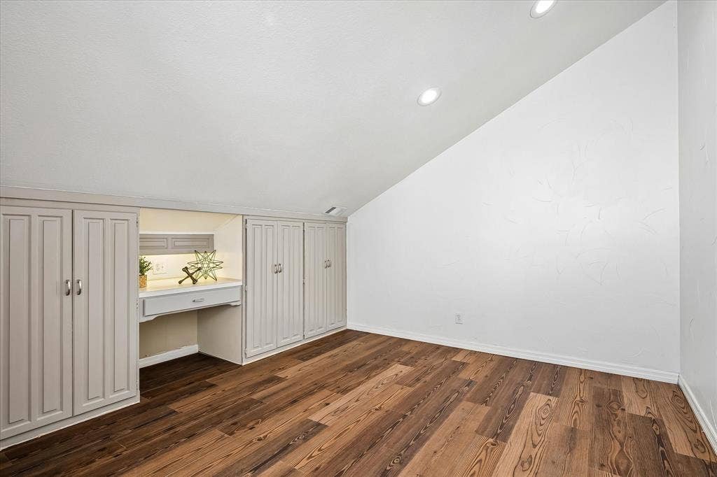 4611 O Connor Court, Irving, TX 75062 Sloped ceiling featuring recessed lighting, wood-finish flooring, and built-in cabinetry with an integrated desk
