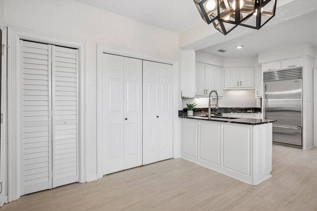 4611 O Connor Court, Irving, TX 75062 Geometric multi-light pendant fixture, white plantation shutters, wood-finish flooring, and crisp white panel doors