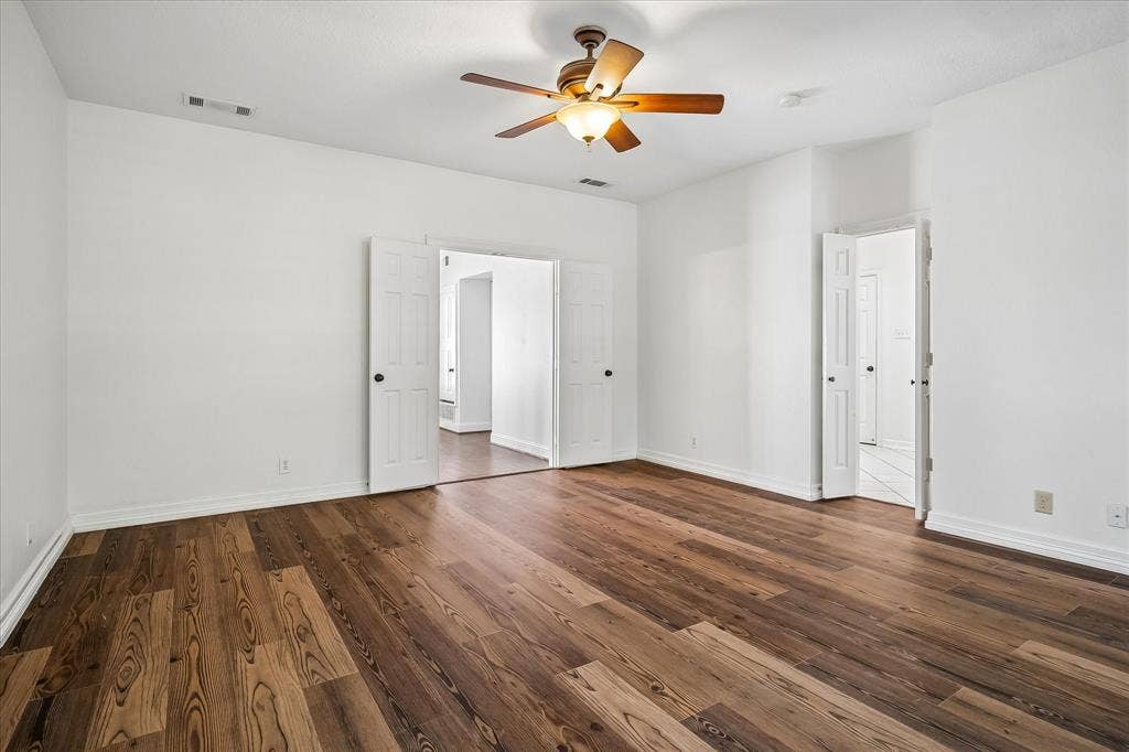 4611 O Connor Court, Irving, TX 75062 Interior space featuring VLP flooring, white walls, double-door entryway, and a ceiling fan with integrated light fixture