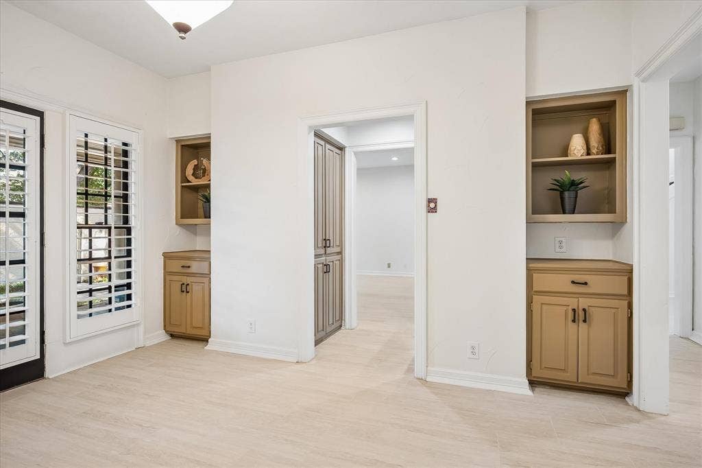 4611 O Connor Court, Irving, TX 75062 Wood-finish flooring, dual built-in cabinetry units with open shelving, full-height pantry storage, and window shutters