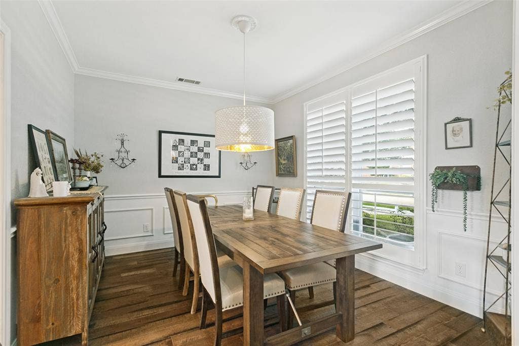 3212 Chippenham Drive, Plano, TX 75093 Dining area featuring wood-finish flooring, wainscoting, crown molding, plantation shutters, and a drum pendant light fixture