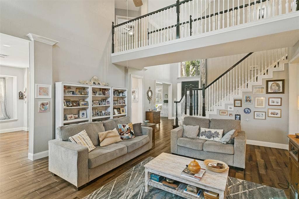 3212 Chippenham Drive, Plano, TX 75093 Two-story interior featuring tall ceilings, wood-finish flooring, a grand staircase with a painted wood balustrade, and built-in shelving