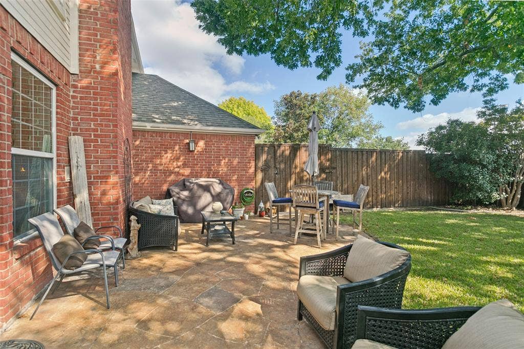 3212 Chippenham Drive, Plano, TX 75093 Flagstone patio featuring a red brick exterior wall, solid wood fencing, and mature trees