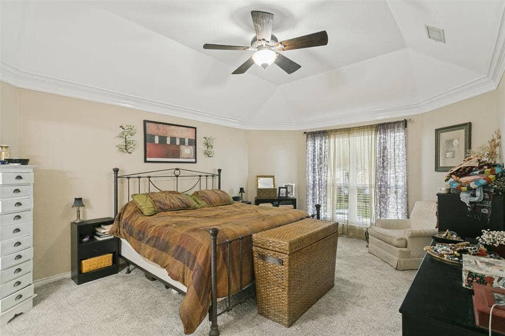 3212 Chippenham Drive, Plano, TX 75093 Tray ceiling with crown molding, ceiling fan with integrated lighting, neutral wall palette, and carpeted flooring