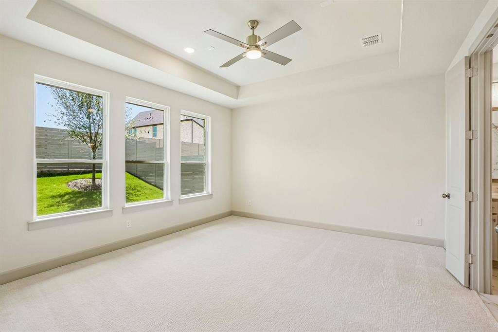4733 Peary Lane, McKinney, TX 75071 High ceilings, plush carpet and a wall of windows create a peaceful and relaxing owner's suite.