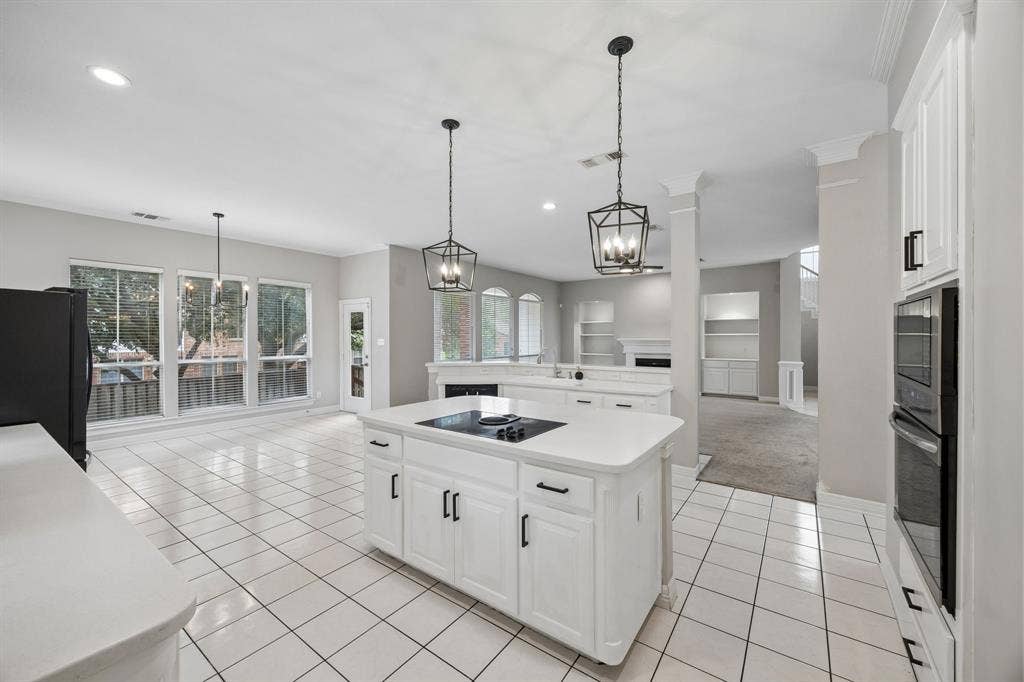 Kitchen featuring a center island with a built-in cooktop, white cabinetry, integrated double wall ovens, recessed lighting, and geometric-style pendant fixtures