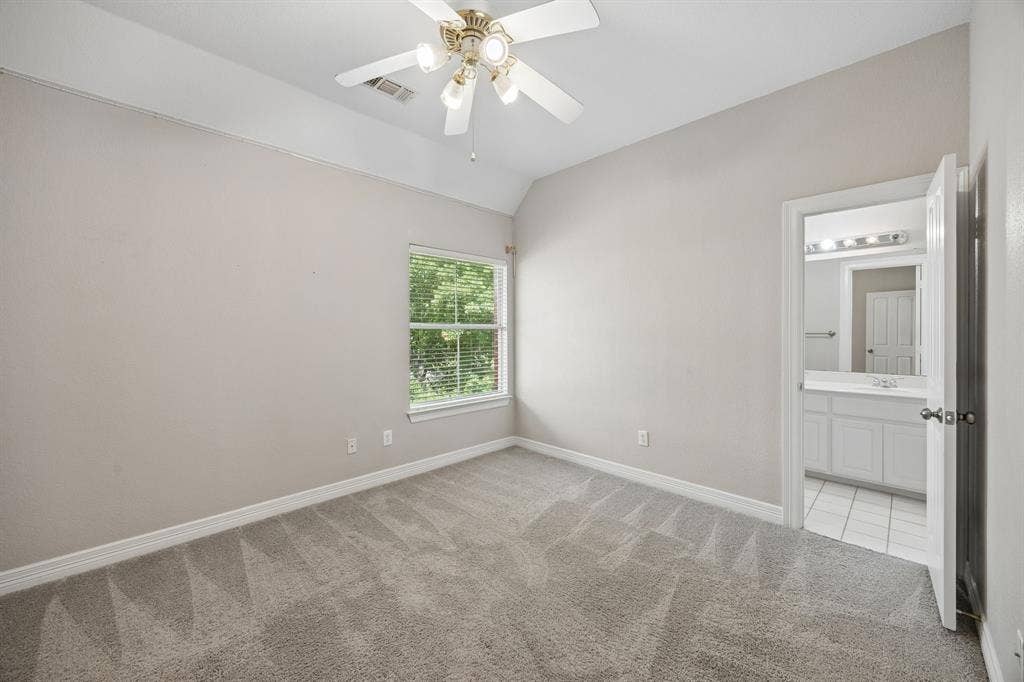 Room featuring high tray ceilings, neutral wall tones, plush wall-to-wall carpeting, and a ceiling fan with multi-light fixture