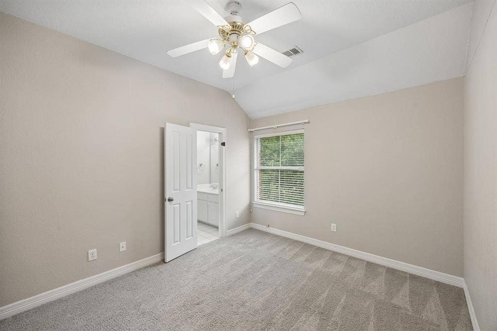 Vaulted ceilings, carpeted flooring, window with blinds, and a multi-light ceiling fan