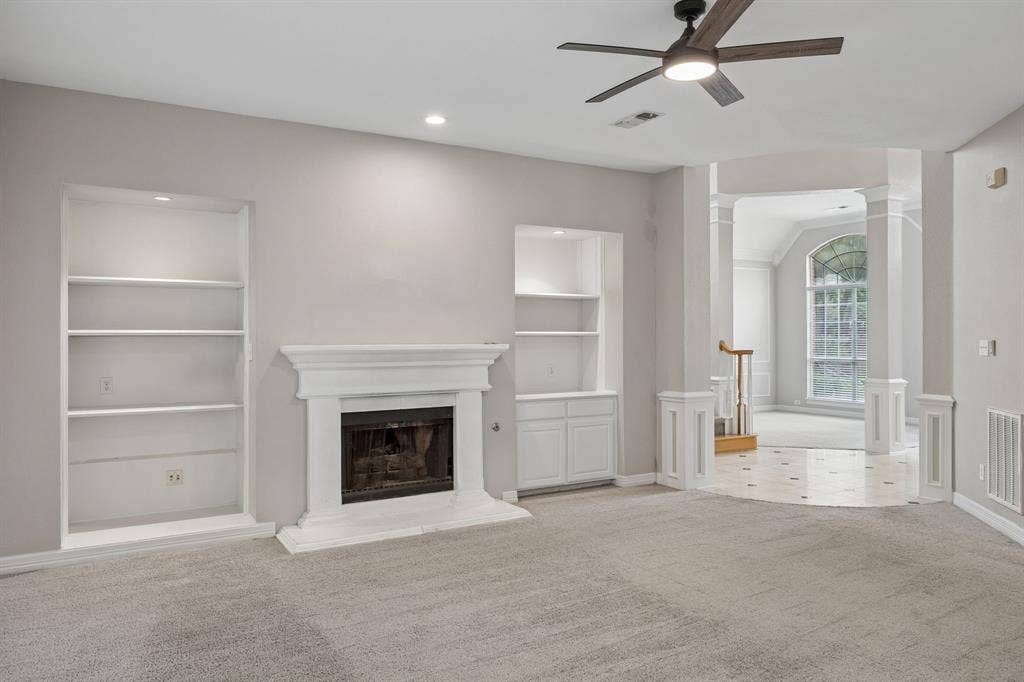 Fireplace with decorative mantle, built-in shelving, recessed ceiling lighting, and a multi-blade ceiling fan