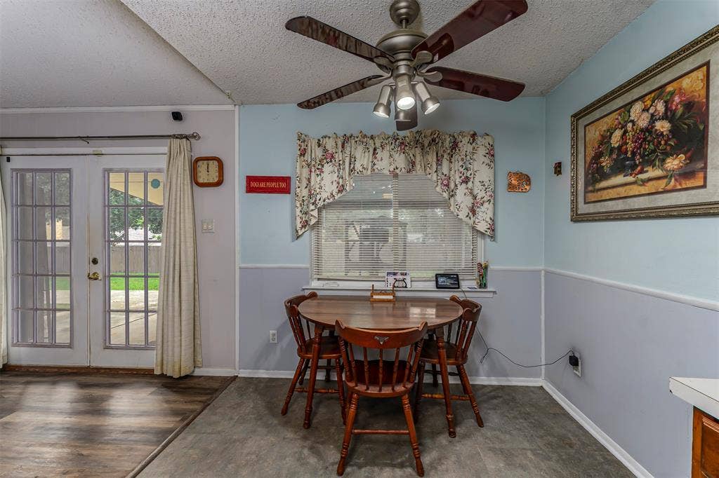 Multi-light ceiling fan, glass-paneled double doors, window with built-in blinds, and two-tone wall finish