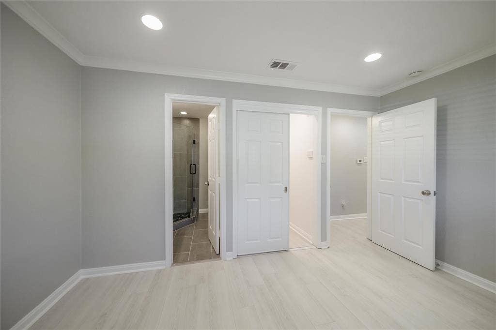 Interior room featuring neutral wall paint, wood-finish flooring, recessed lighting, and multi-panel interior doors