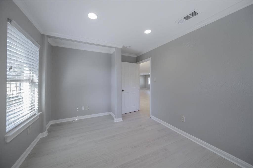 Room featuring light-toned wood-finish flooring, recessed lighting, crown molding, and horizontal blind window treatments