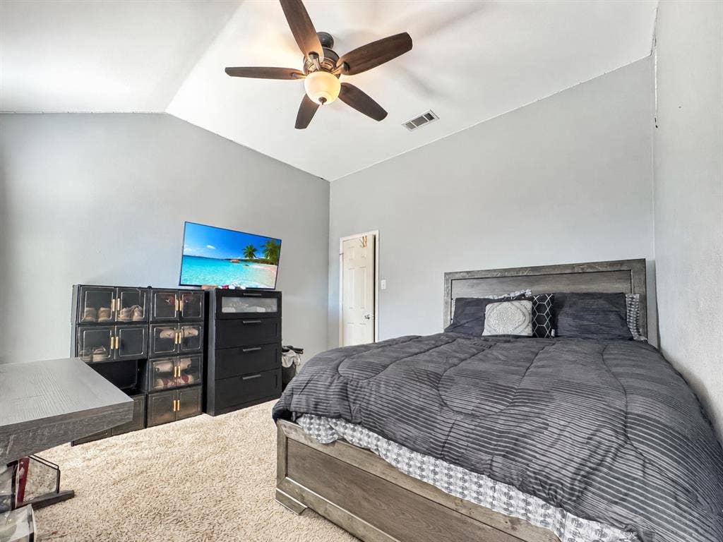Vaulted ceiling featuring a central five-blade ceiling fan with integrated light fixture