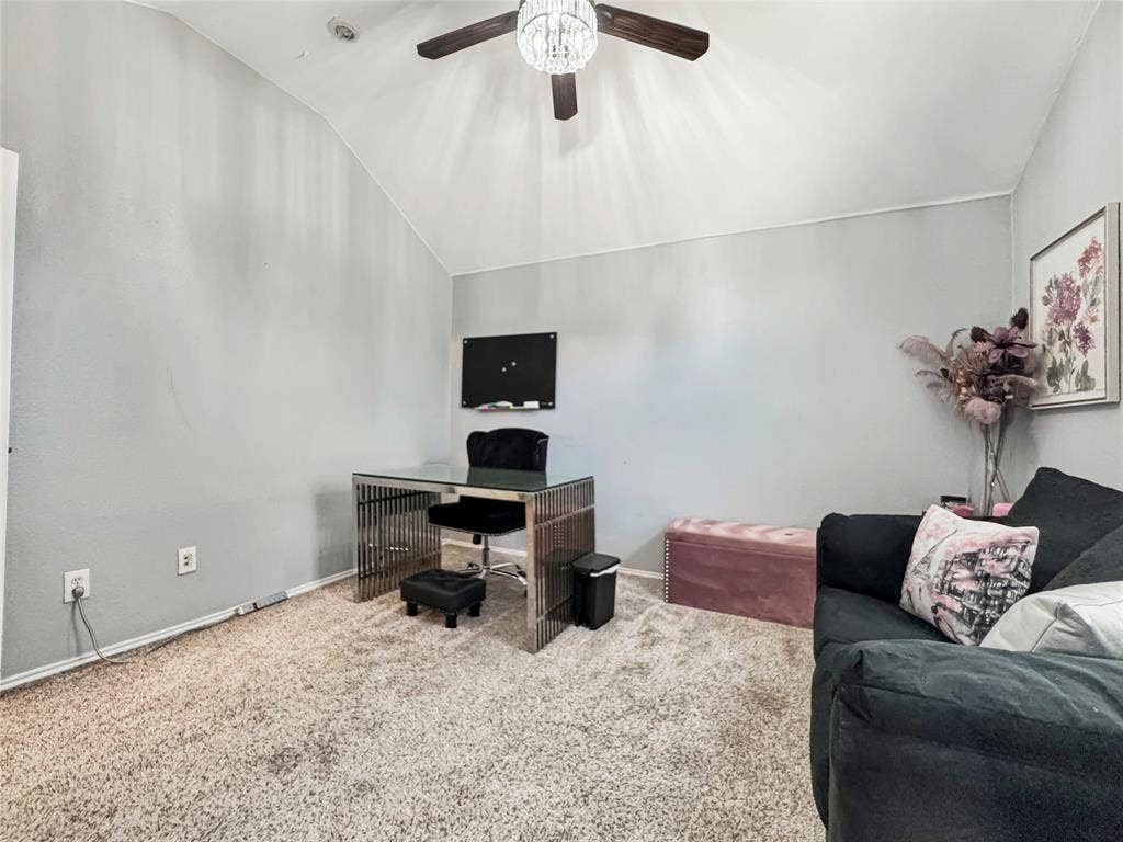 Vaulted ceiling, plush carpeting, and crystal-accented ceiling fan with integrated lighting
