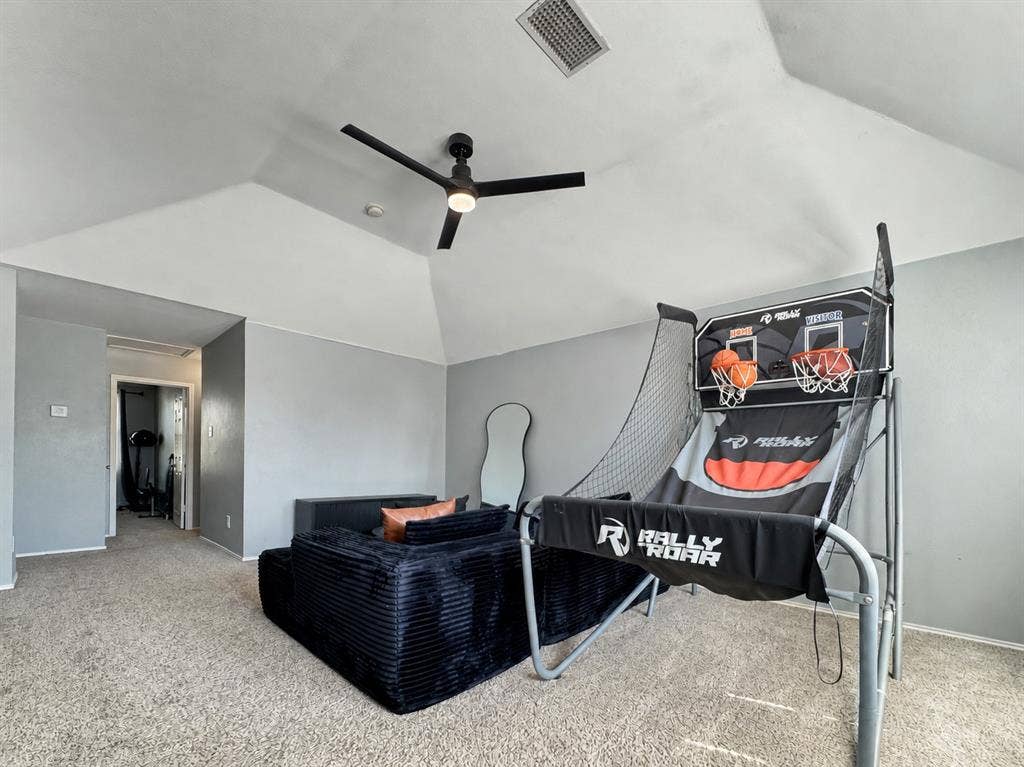 Vaulted ceiling featuring a central matte black ceiling fan with integrated light