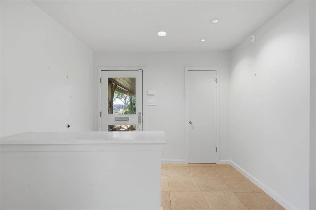7606 Currin Drive, Dallas, TX 75230 Entryway featuring neutral tile flooring, recessed ceiling lighting, a solid-core interior door, and an exterior door with a glass pane