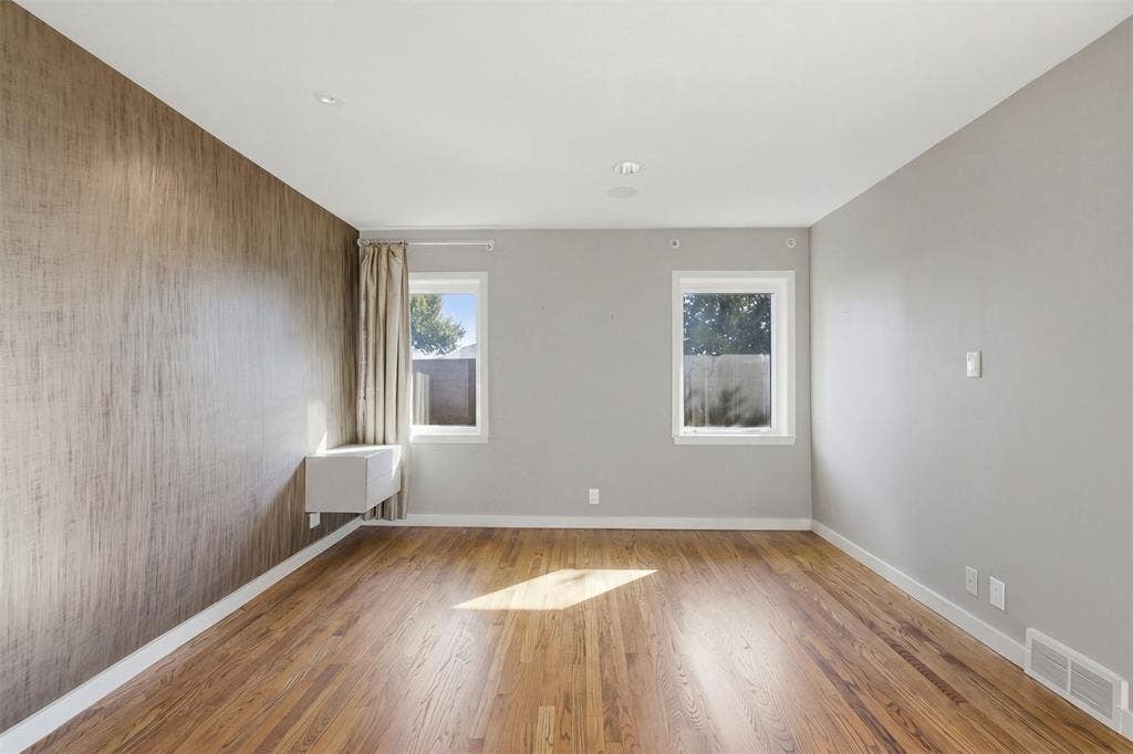 7606 Currin Drive, Dallas, TX 75230 Room featuring wood-finish flooring, a textured accent wall, recessed ceiling lighting, and two windows