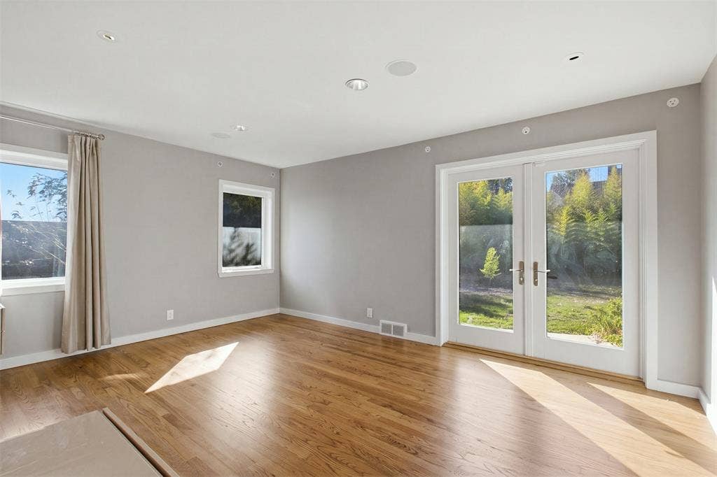 7606 Currin Drive, Dallas, TX 75230 Interior space featuring wood-finish flooring, recessed lighting, double-paned windows, and glass-paneled double doors with metal hardware