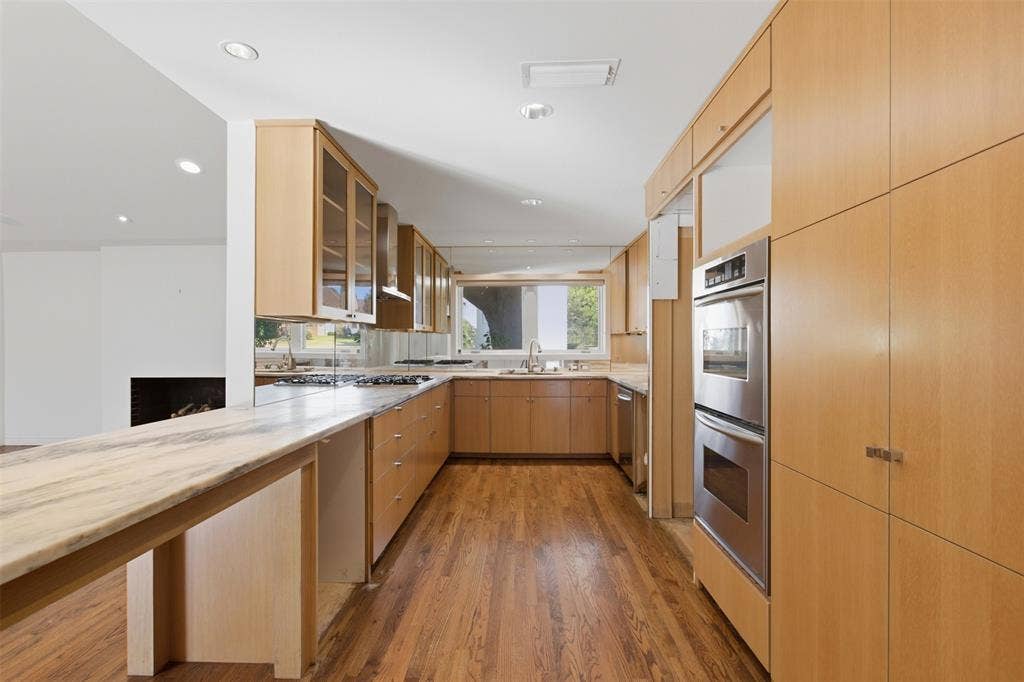 7606 Currin Drive, Dallas, TX 75230 Kitchen featuring flat-panel wood cabinetry, natural stone countertops, hardwood flooring, recessed lighting, and stainless steel double wall ovens