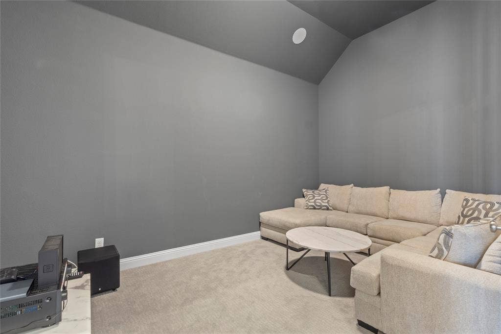 Vaulted ceilings, neutral wall tones, and plush wall-to-wall carpeting