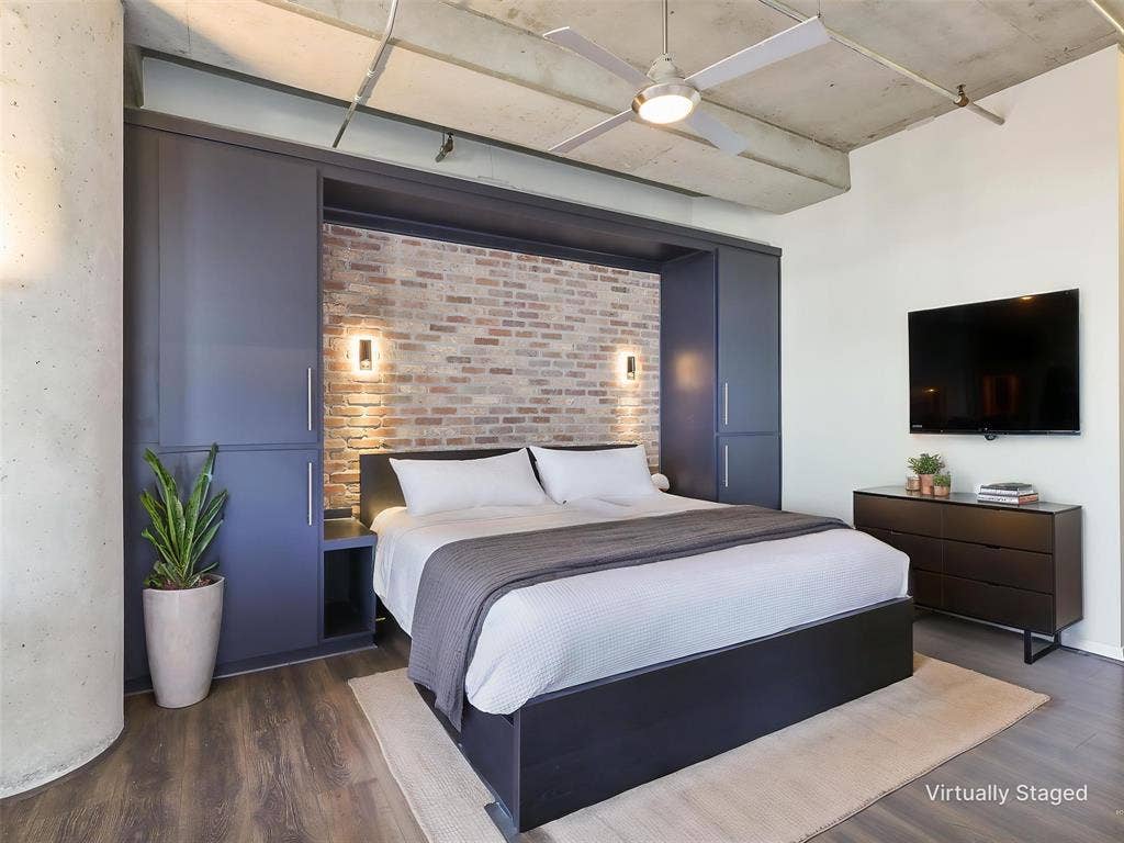 1001 Belleview Street, #307, Dallas, TX 75215 Primary Bedroom with built-in’s brick accent wall,and reading lights