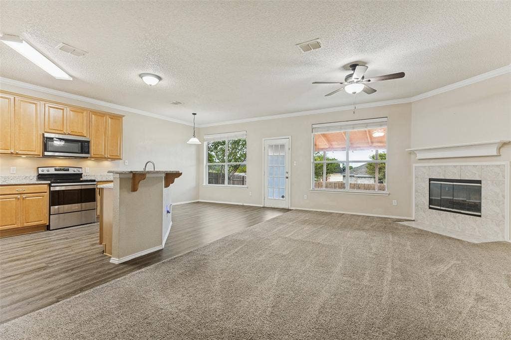 Kitchen featuring light wood cabinetry, stainless steel appliances, and a peninsula counter