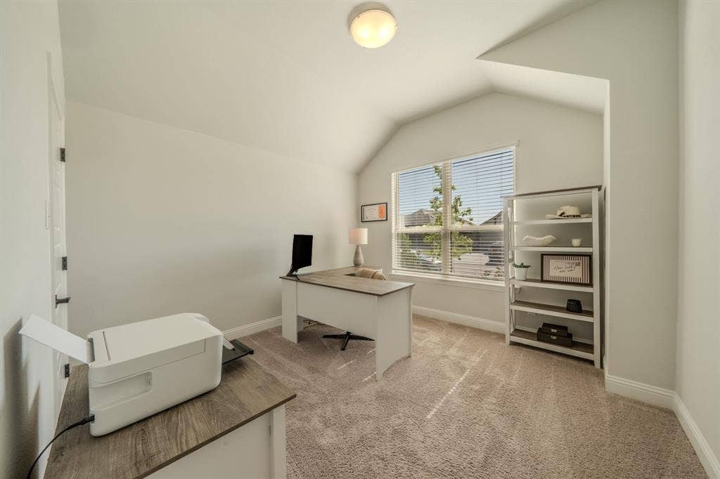 Room featuring a vaulted ceiling, neutral wall tones, carpeted flooring, and a large window with horizontal blinds