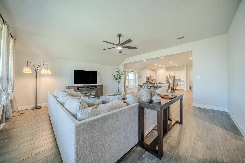 Open-concept interior featuring wood-finish tile flooring, recessed lighting, and a ceiling fan with integrated lighting