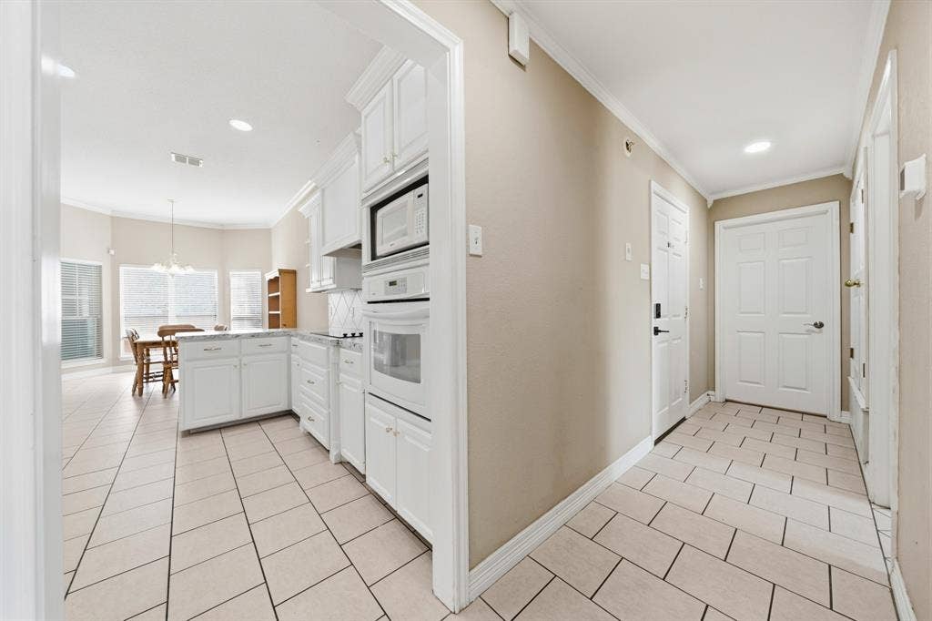 Kitchen featuring white cabinetry, built-in double oven, and neutral tile flooring throughout