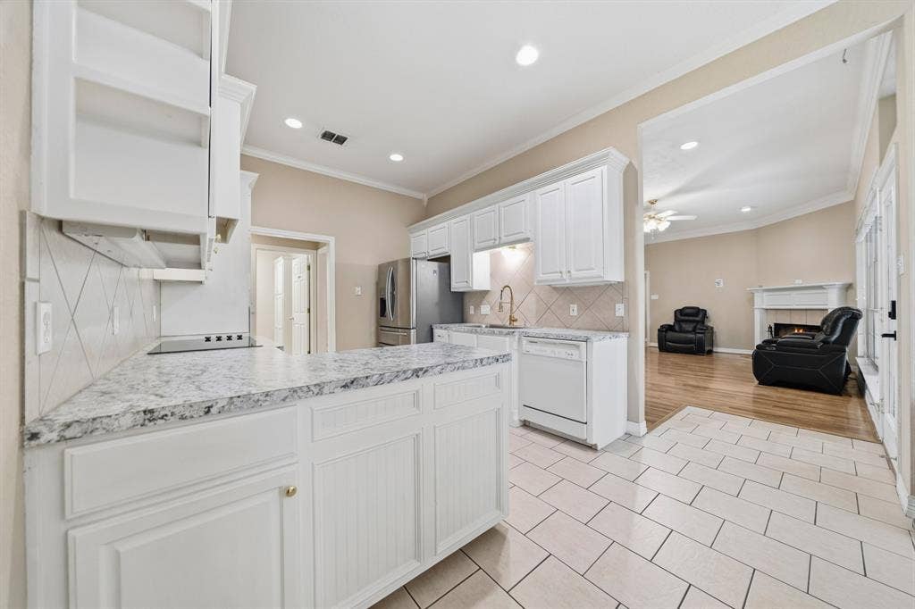 Kitchen featuring white cabinetry, stone-finish countertops, ceramic tile flooring, and stainless steel appliances