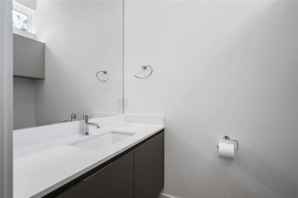 4904 Lexington Court, Dallas, TX 75206 Floating vanity with a light-toned countertop, integrated rectangular sink, wall-spanning mirror, and chrome hardware
