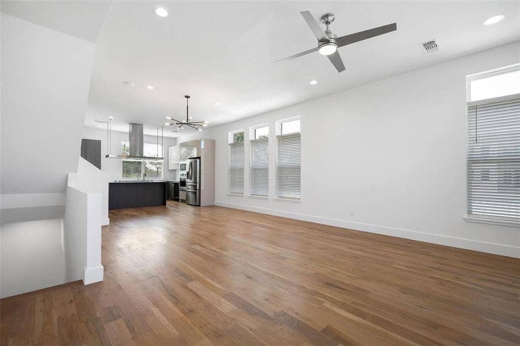 4904 Lexington Court, Dallas, TX 75206 Open-concept interior featuring wood-finish flooring, recessed lighting, a modern ceiling fan, multiple windows with blinds, and a kitchen equipped with a stainless steel range hood