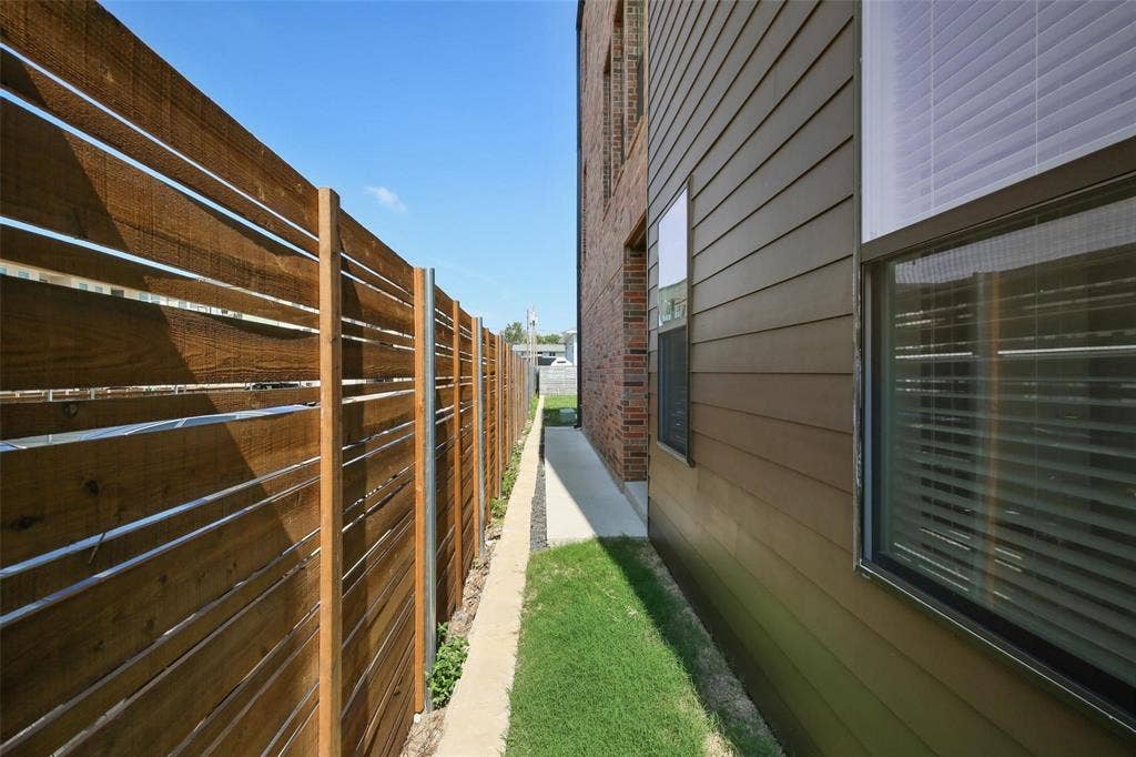 4904 Lexington Court, Dallas, TX 75206 Horizontal wood-slat privacy fence with metal support posts, concrete pathway, and horizontal siding exterior