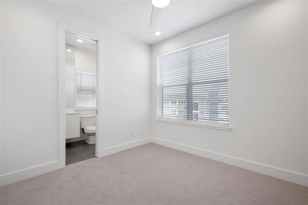 4904 Lexington Court, Dallas, TX 75206 Neutral-toned interior space featuring wall-to-wall carpeting, recessed ceiling lighting, a ceiling fan, a window with horizontal blinds, and access to a bathroom with tile flooring