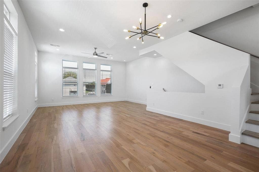 4904 Lexington Court, Dallas, TX 75206 Open-concept interior featuring wood-finish flooring, multi-pane windows, a contemporary sputnik-style chandelier, a ceiling fan, and a staircase with wood-tread stairs