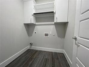 Utility room featuring wood-finish flooring, white upper cabinetry, and an integrated hanging rod