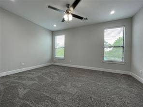 Neutral-toned interior featuring wall-to-wall carpeting, recessed lighting, a ceiling fan with integrated light fixture, and dual windows