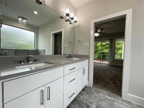 Dual-sink vanity with a solid-surface countertop, white cabinetry with metallic hardware, large wall-mounted mirror, and multi-bulb vanity lighting