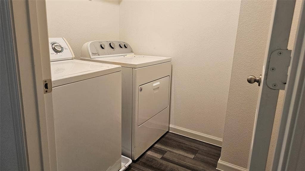 Laundry area featuring wood-finish flooring and a top-load washer and dryer
