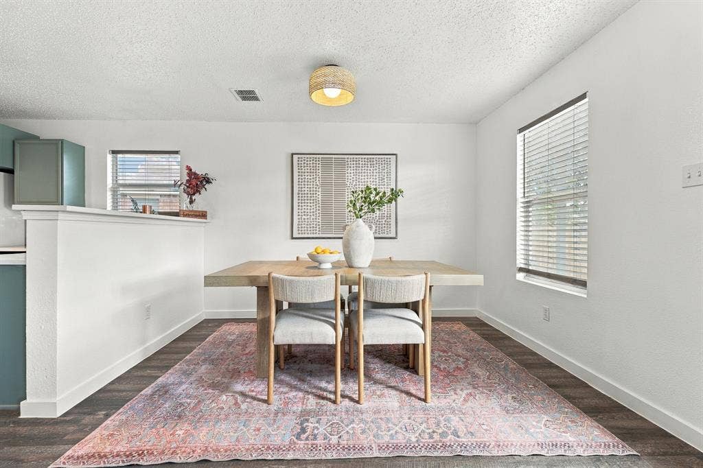 Neutral interior featuring wood-finish flooring, a textured drum-style ceiling light fixture, and horizontal window blinds