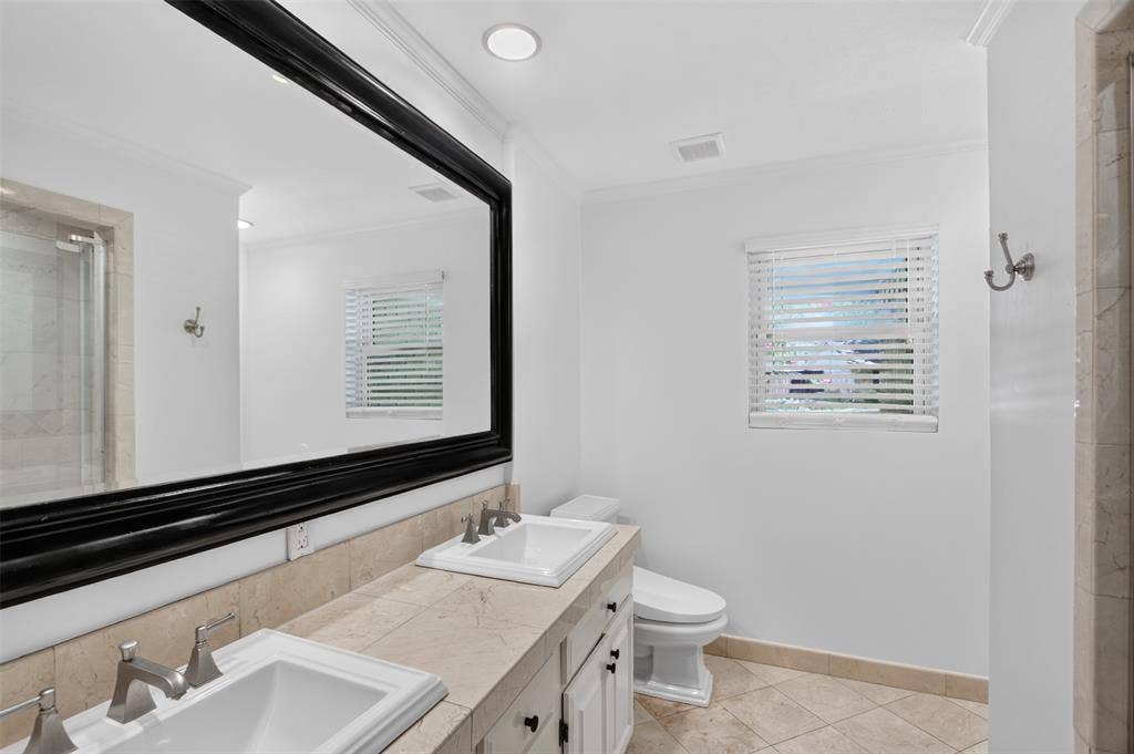 3230 Camelot Drive, Dallas, TX 75229 Full size bathroom adjacen to the bedrooms. Dual sinks, oversized walk in shower, tile floor, tile counter tops and so many cabinets. Floor to ceiling linen closet behind the door and updated Bidet. Bathroom freshly painted August 2026