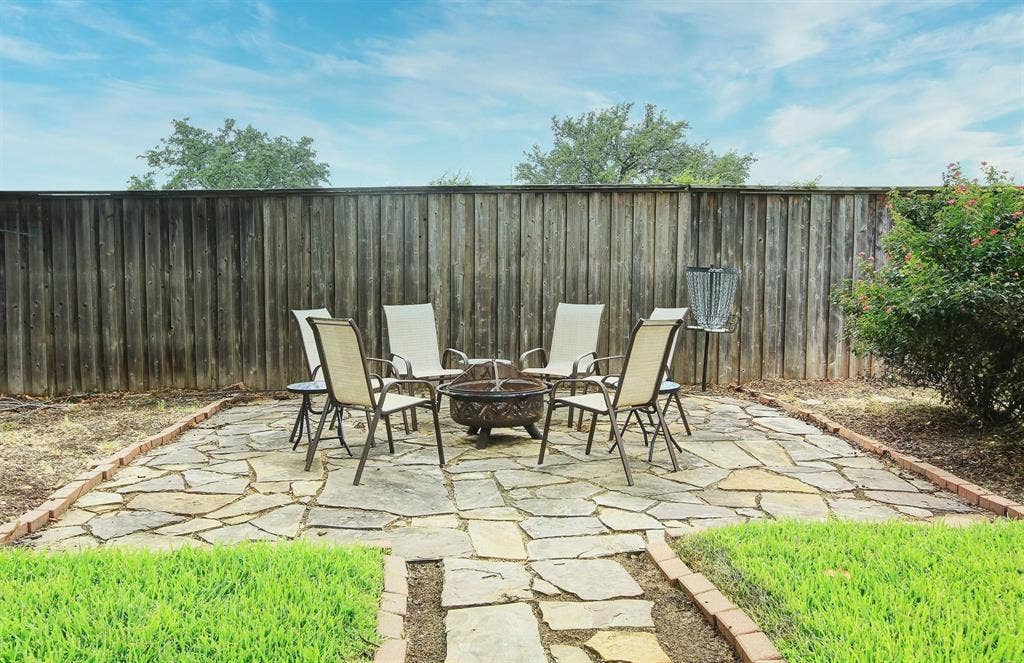 3230 Camelot Drive, Dallas, TX 75229 Beautifully designed backyard retreat with a firepit on inlaid flagstone, perfect for relaxing and entertaining.