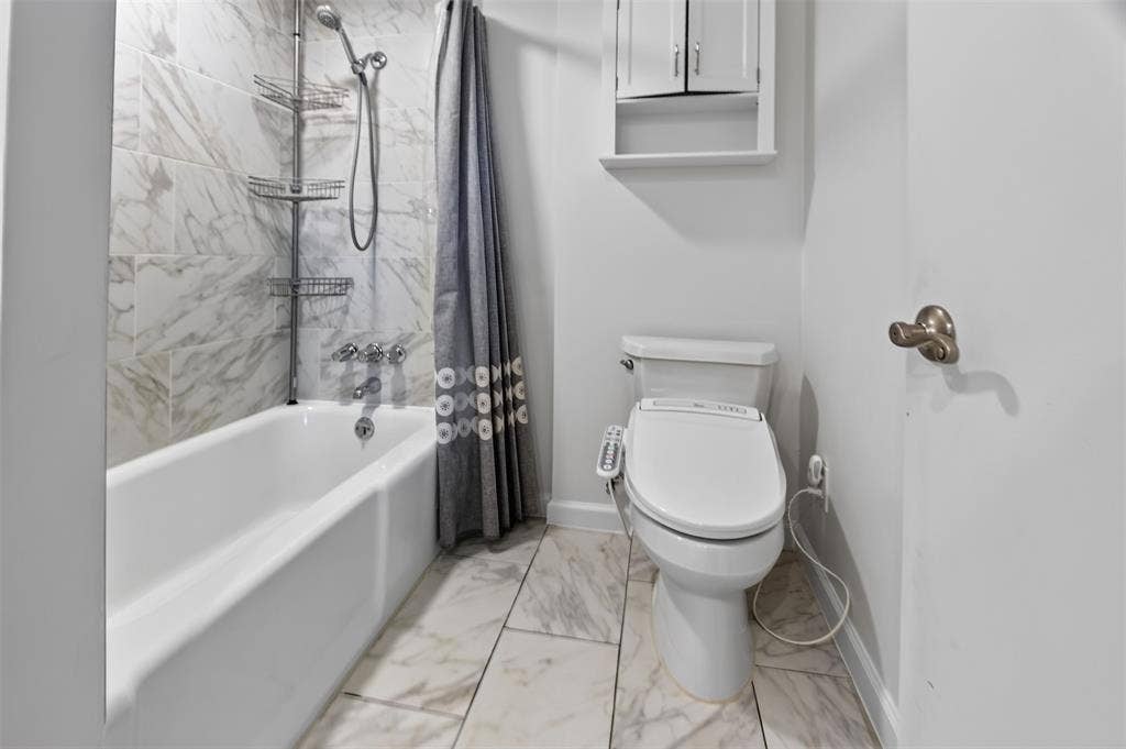 3230 Camelot Drive, Dallas, TX 75229 View of shower tub enclosure in Jack N Jill bath. Updated flooring and shower enclosure. Cabinet above Bidet. August 2026 wallpaper removed walls freshly painted.