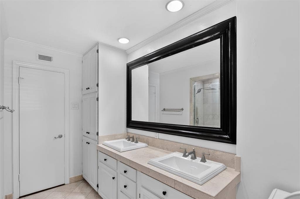 3230 Camelot Drive, Dallas, TX 75229 Another view of Primary bath with dual sinks, oversize framed mirror, recessed lights. Floor to ceiling cabinets allow for storage of linens, towels and additional toiletries. Freshly painted August 2026
