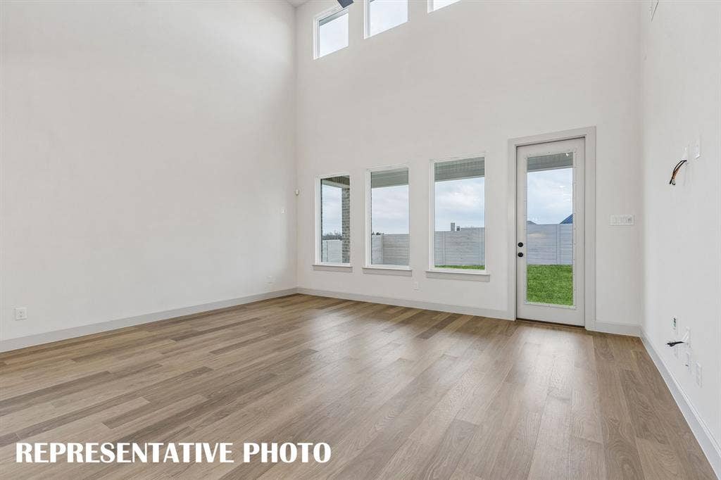 4520 Sunfish Lane, McKinney, TX 75071 Dual story windows flood this family room with natural light! REPRESENTATIVE PHOTO