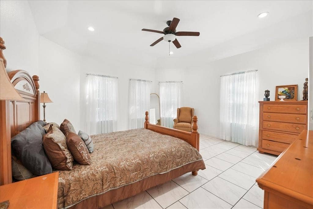 7320 County Road 3512, Quinlan, TX 75474 Vaulted ceiling featuring a central multi-blade ceiling fan and recessed lighting, finished with tile flooring and multiple windows