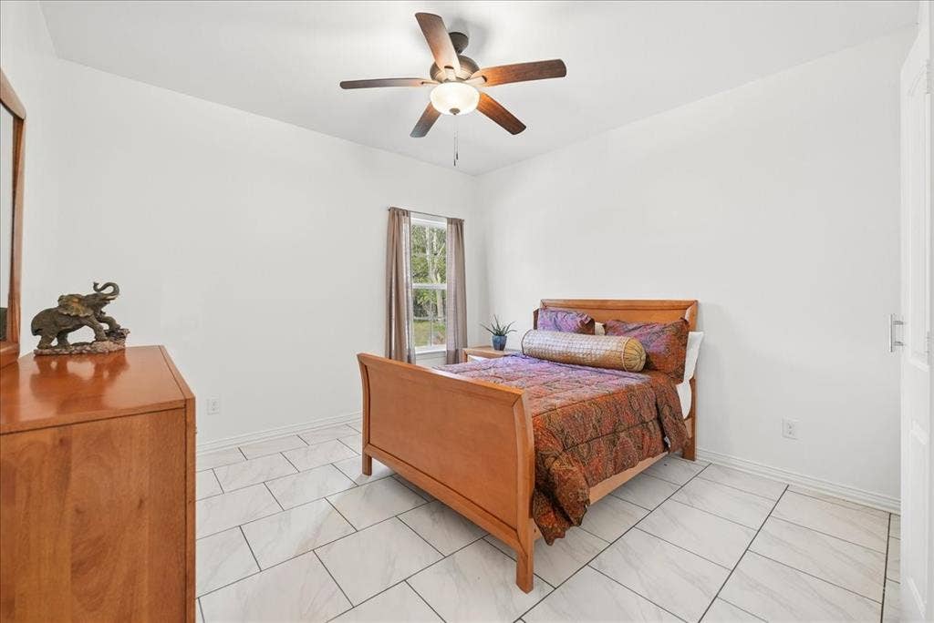 7320 County Road 3512, Quinlan, TX 75474 Light-filled room featuring large-format rectangular floor tile and a central ceiling fan with integrated lighting