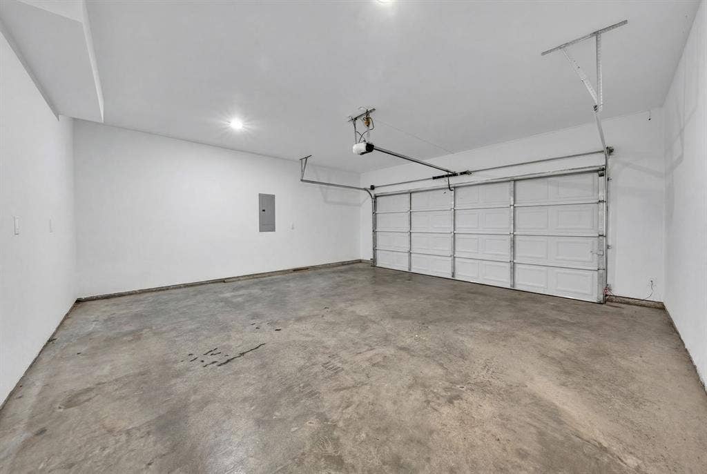 3639 Pueblo Street, Dallas, TX 75212 Attached two-car garage featuring a sectional door, concrete flooring, recessed lighting, and an automated opener
