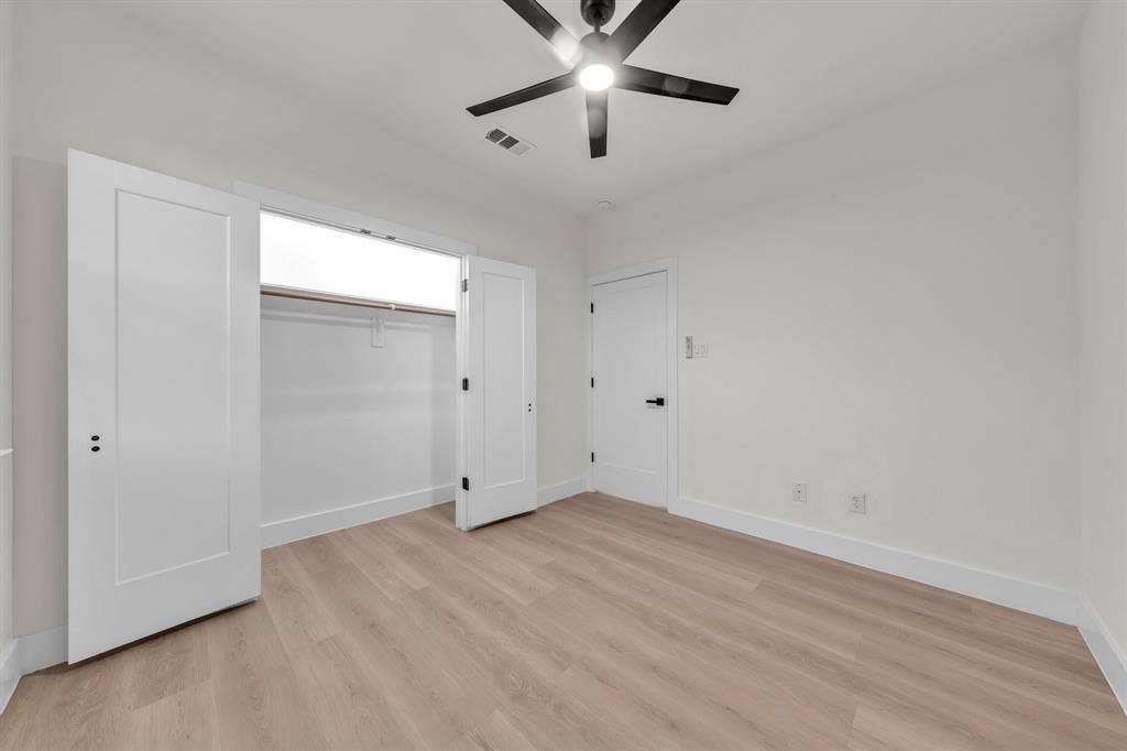 3639 Pueblo Street, Dallas, TX 75212 Wood-finish flooring, matte black ceiling fan with integrated lighting, shaker-style interior doors with matte black hardware, and double-door closet