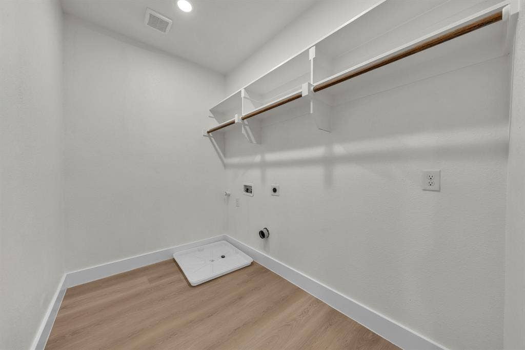 3639 Pueblo Street, Dallas, TX 75212 Utility room featuring wood-finish flooring, white shelving with an integrated clothes rod, and an appliance drain pan